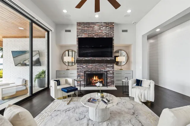 a living room with furniture a flat screen tv and a fireplace