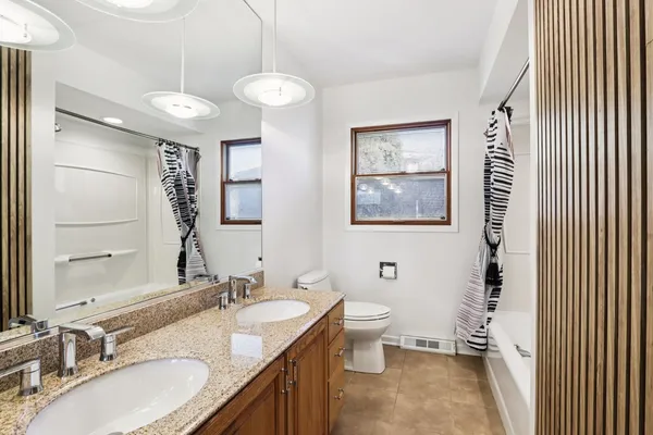 a bathroom with a granite countertop sink a mirror and a shower