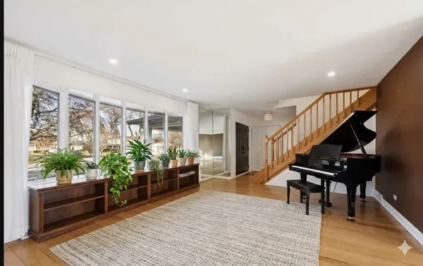 a view of an empty room with wooden floor and stairs