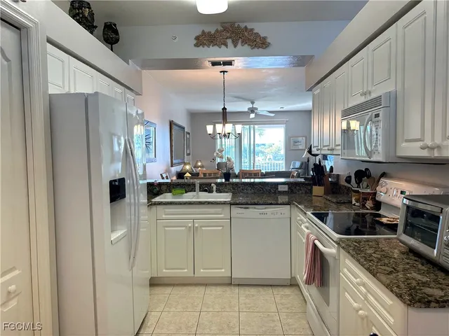 a kitchen with a sink dishwasher a refrigerator and cabinets