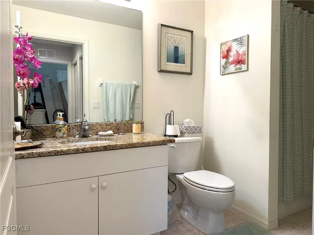 a bath room with a toilet a sink and mirror