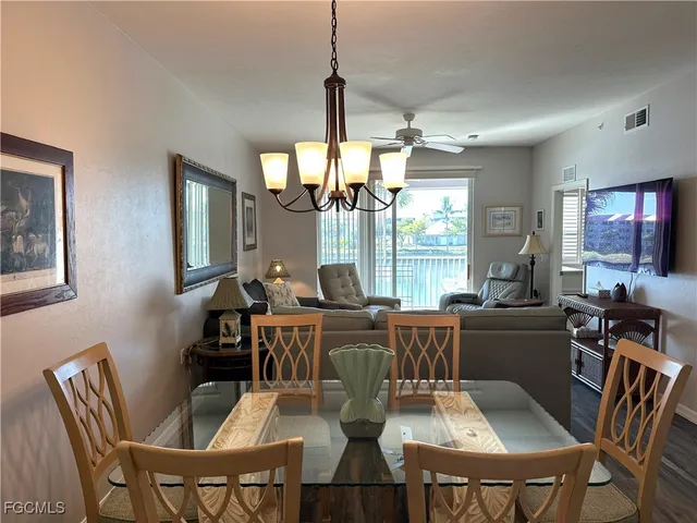 a view of a dining room with furniture a chandelier and wooden floor
