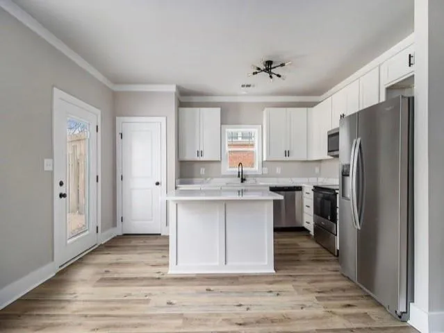 a kitchen with a refrigerator sink and cabinets