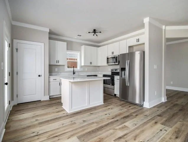 a kitchen with stainless steel appliances granite countertop a refrigerator and a stove top oven
