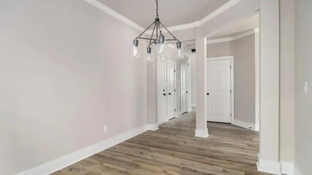 a view of a hallway with wooden floor and closet