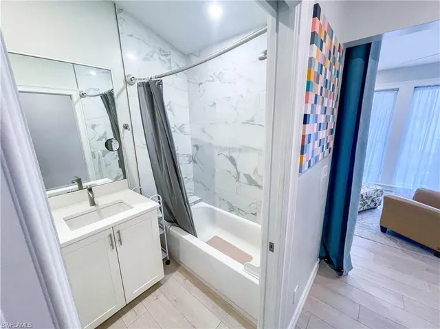 a bathroom with a tub sink a mirror a shower and vanity