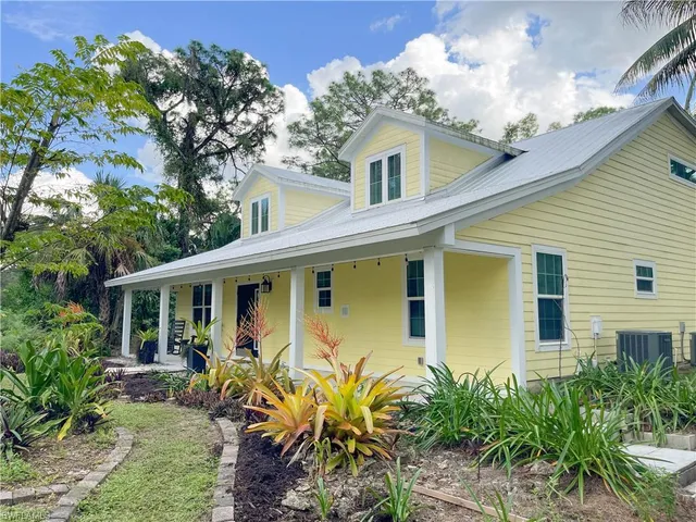 a front view of a house with yard and outdoor seating