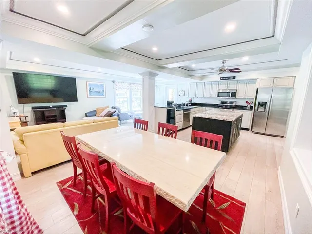 a living room with stainless steel appliances furniture and a flat screen tv