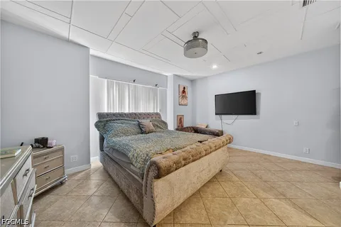 a spacious bedroom with a bed and a flat screen tv