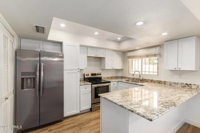 a kitchen with stainless steel appliances granite countertop a sink stove and refrigerator