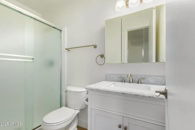 a bathroom with a sink toilet vanity and shower