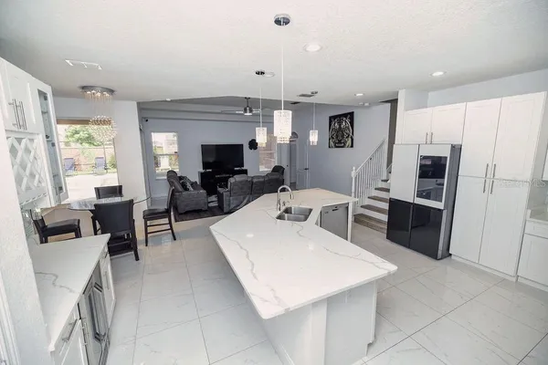 a large kitchen with stainless steel appliances kitchen island granite countertop a refrigerator and a sink