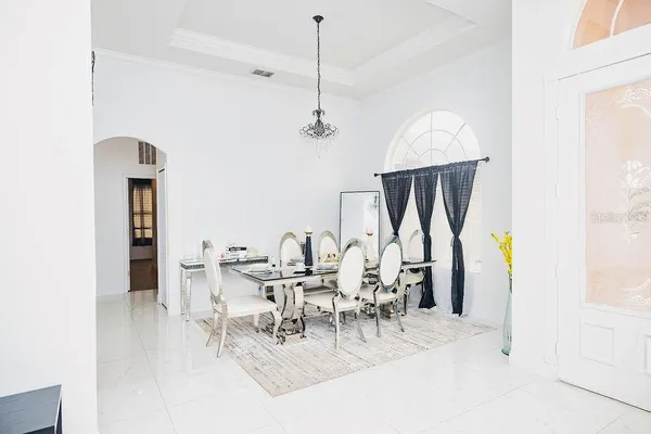 a living room with furniture chandelier and a dining table