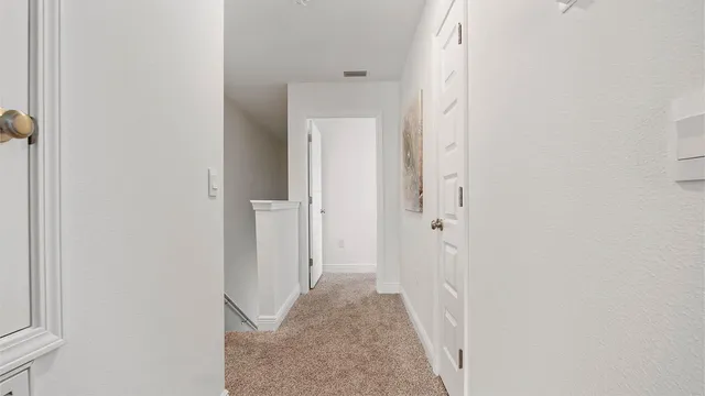 a view of a hallway with wooden floor and closet