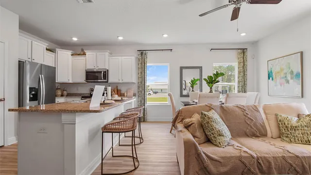 a living room with stainless steel appliances furniture and a view of kitchen