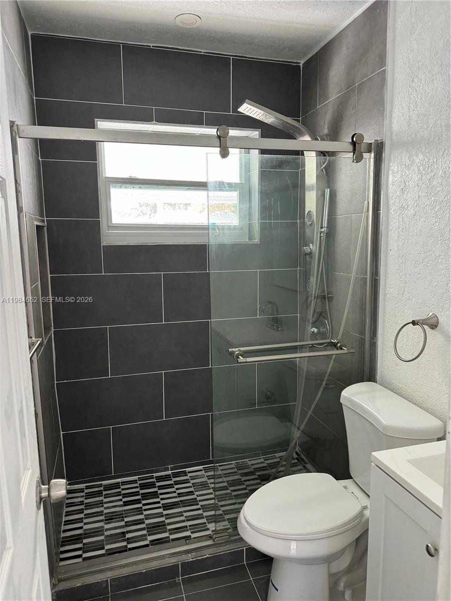 2400 North 57th Way Hollywood, FL 33021 - Photo 7 of 9 a bathroom with a toilet a window and shower