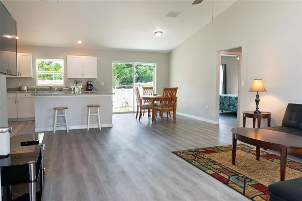 a living room with furniture a window and wooden floor