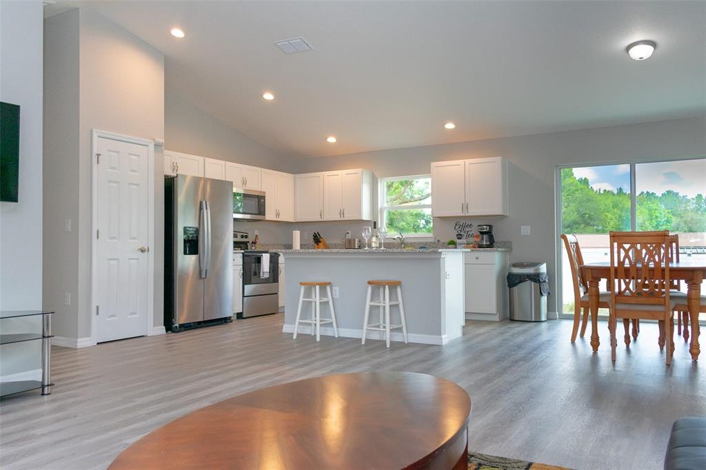 20109 Southwest 84th Street Dunnellon, FL 34431 - Photo 4 of 10 a kitchen with a table chairs refrigerator and cabinets
