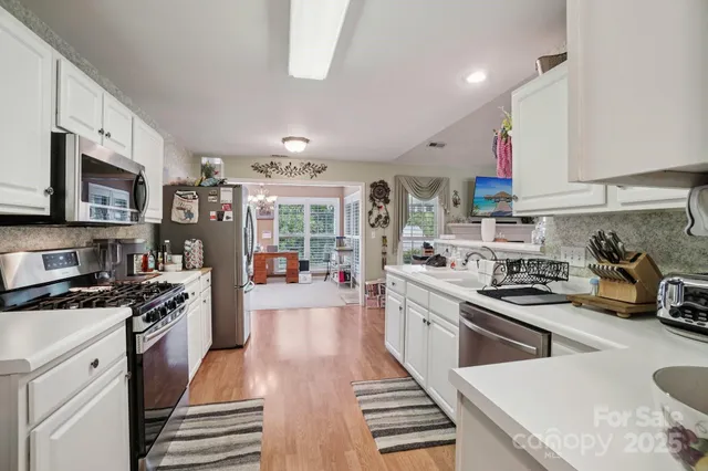 a kitchen with stainless steel appliances granite countertop a stove a sink dishwasher and a microwave oven with cabinets