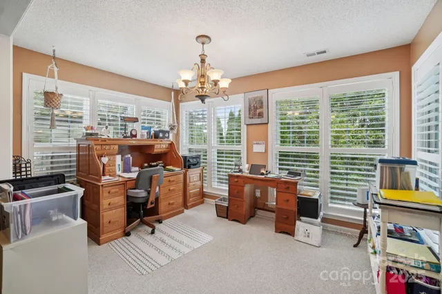 a work room with furniture and large windows
