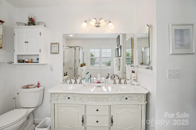 a bathroom with a granite countertop toilet sink and mirror