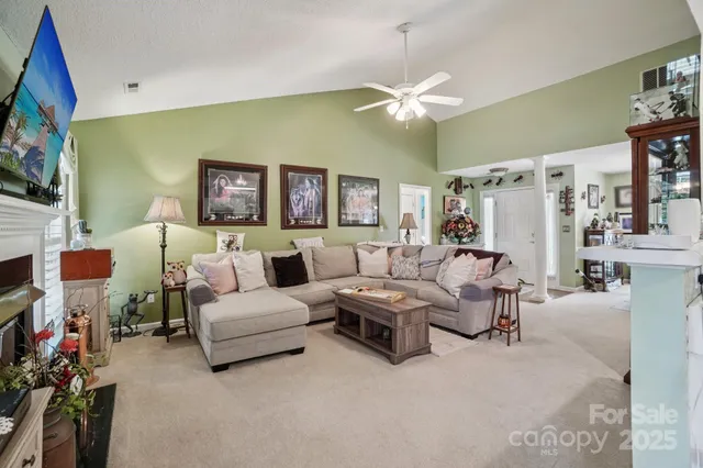 a living room with furniture a flat screen tv and a fireplace