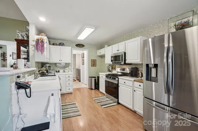 a kitchen with white cabinets and stainless steel appliances