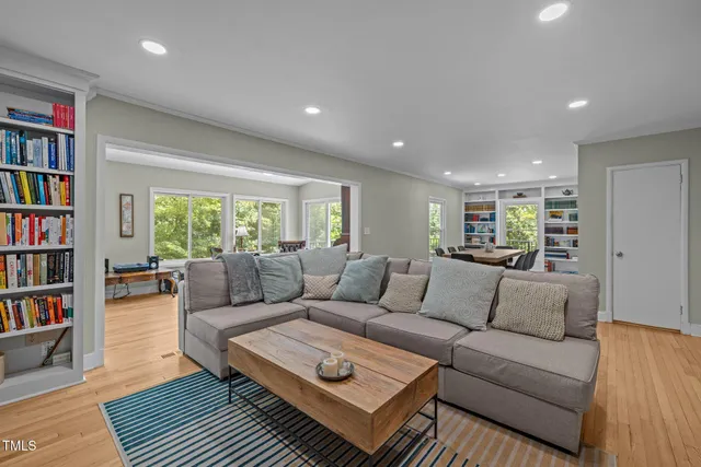 a living room with a fireplace and a book shelf