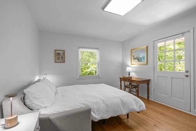 a bedroom with a bed and a table in it next to a window