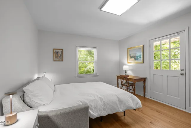 a bedroom with a bed and a table in it next to a window