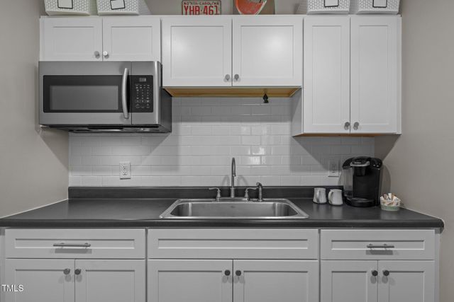 a kitchen with appliances a sink and cabinets