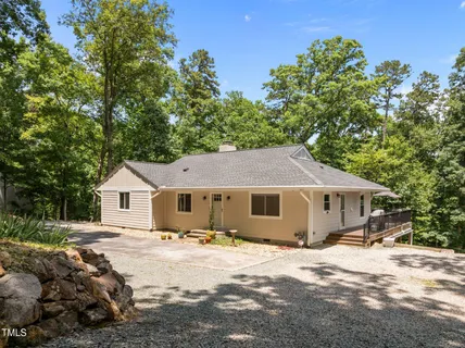 a view of a yard in front of a house with large tree