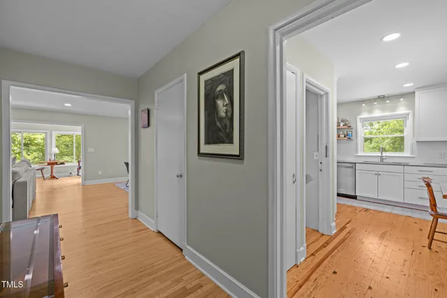 a view of a hallway with wooden floor and windows