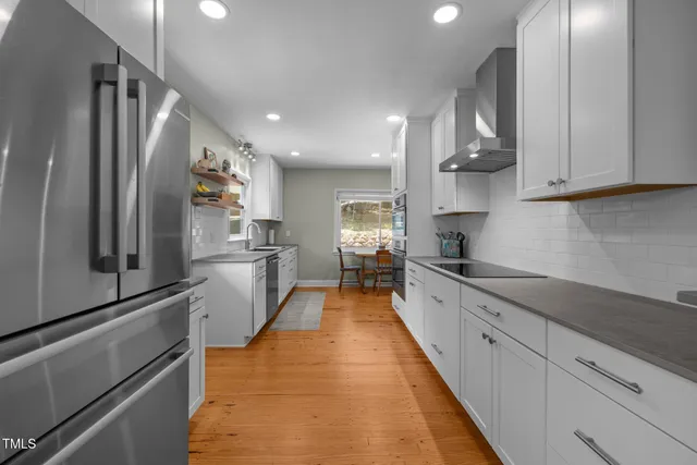 a kitchen with stainless steel appliances granite countertop white cabinets and window
