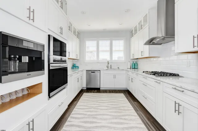 a kitchen with granite countertop white cabinets and white appliances