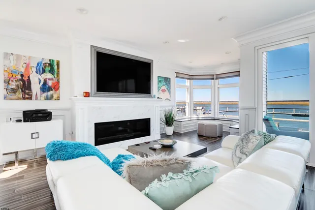 a living room with furniture a flat screen tv and a fireplace