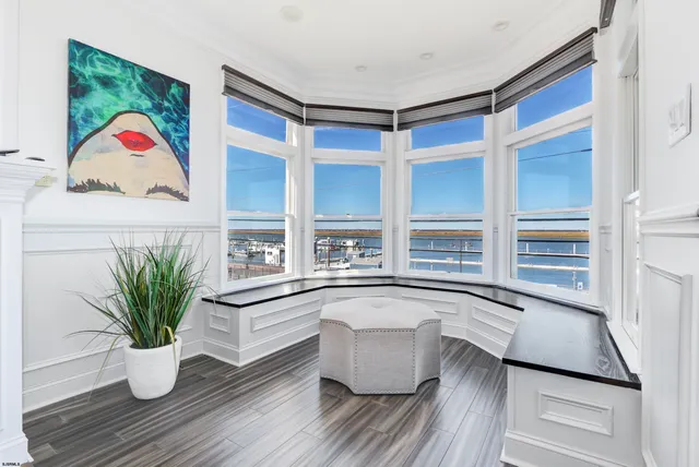 a white kitchen with a potted plant on the counter and a wooden floor