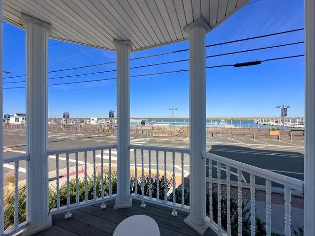 a view of a balcony with wooden floor and seating space