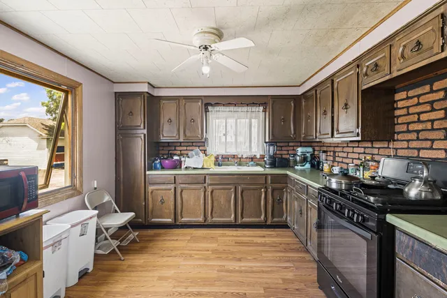 a kitchen with a sink appliances cabinets and furniture