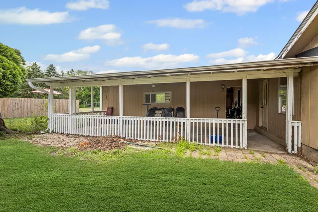 a view of a house with a yard and deck