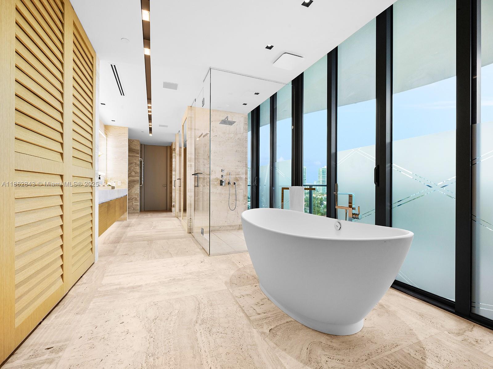 19575 Collins Avenue, Unit 9 Sunny Isles Beach, FL 33160 - Photo 27 of 91 a spacious bathroom with a bathtub and shower