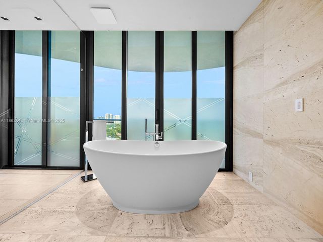 a bedroom with a large bed and a flat tv screen on dresser