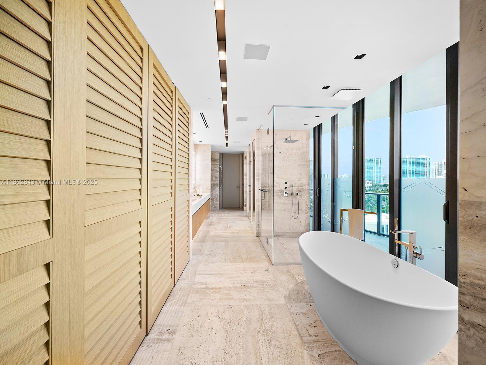 19575 Collins Avenue, Unit 9 Sunny Isles Beach, FL 33160 - Photo 32 of 91 a spacious bathroom with a bathtub and shower