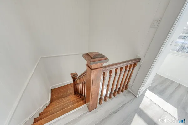 a view of staircase with railing and white walls