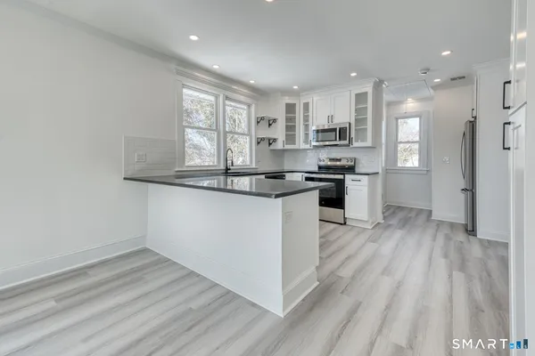 a kitchen with stainless steel appliances granite countertop a stove a sink and a refrigerator