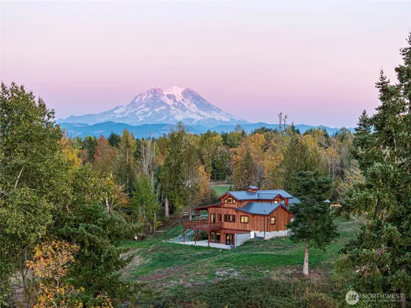 a front view of a house with a garden and trees