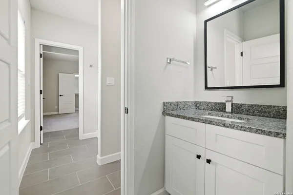 a bathroom with a granite countertop sink and a mirror