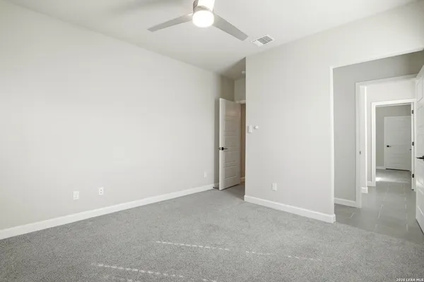 an empty room with a ceiling fan and a window