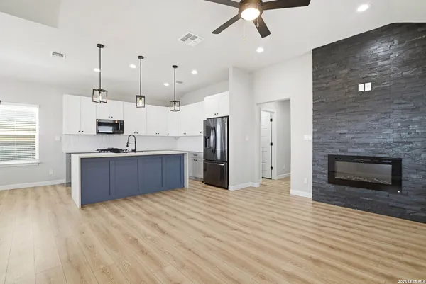 a large kitchen with stainless steel appliances granite countertop a granite counter tops and a wooden floors
