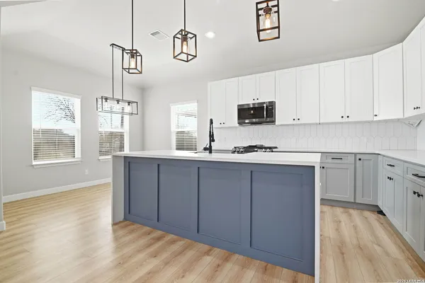 a kitchen with granite countertop a stove a sink and a microwave
